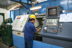 Man Working CNC Machining Lathe